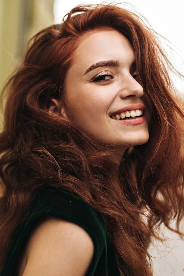 A person with red hair smiling